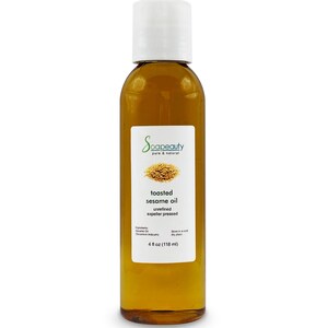 May include: A clear glass bottle with a white cap filled with toasted sesame oil. The label reads "Soapeauty pure & natural toasted sesame oil unrefined expeller pressed" and lists the ingredients as "Sesame Oil (Sesamum indicum)". The bottle contains 4 fluid ounces (118 ml) of oil.