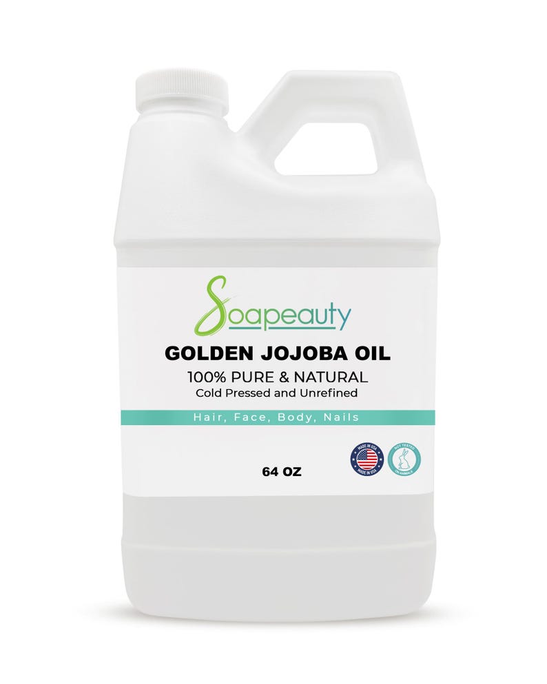 May include: A white plastic jug of Soapeauty Golden Jojoba Oil. The label includes the text "100% Pure & Natural" and "Cold Pressed and Unrefined". It is for hair, face, body, and nails. The jug contains 64 oz of oil.