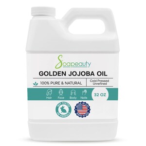May include: A white plastic jug of Soapeauty Golden Jojoba Oil. The label includes text: "100% Pure & Natural", "Cold Pressed Unrefined", and "32 OZ". The label also features icons for hair, face, body, and nails, along with "Not Tested on Animals" and "Made in USA" seals.