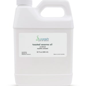 May include: A white plastic jug with a handle containing 32 fluid ounces (946 milliliters) of toasted sesame oil. The label reads "Soapeauty pure & natural toasted sesame oil unrefined expeller pressed 32 fl oz (946 ml) Store in a cool dry place".