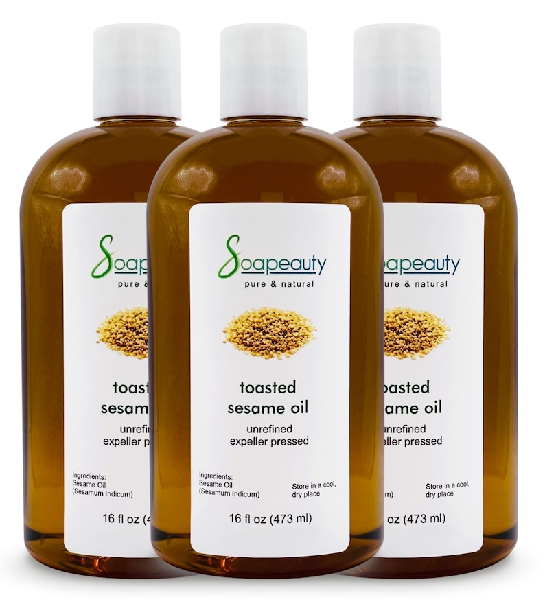May include: Three 16-ounce bottles of toasted sesame oil, unrefined and expeller pressed. The bottles are amber glass with white labels and a white cap. The label says "Soapeauty pure & natural" and includes the ingredients, "Sesame Oil (Sesamum Indicum)".