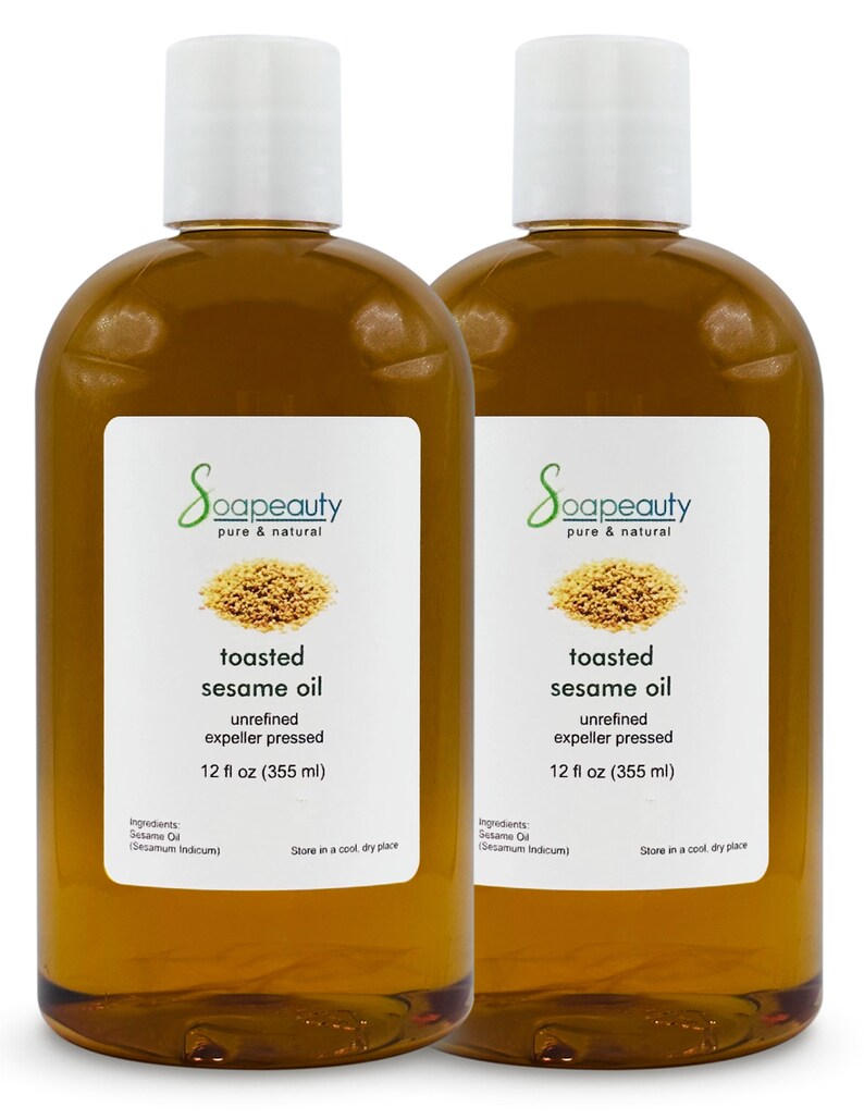 May include: Two clear glass bottles of toasted sesame oil, each containing 12 fluid ounces (355 ml). The bottles have white labels with the brand name "Soapeauty" and the words "toasted sesame oil" printed in black. The labels also include the ingredients, "Sesame Oil (Sesamum Indicum)", and instructions to store in a cool, dry place.