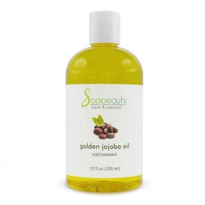 May include: A clear bottle filled with golden jojoba oil. The label reads "Soapeauty pure & natural" and "golden jojoba oil cold pressed". The bottle contains 12 fl oz (355 ml) of oil. A graphic of jojoba beans and leaves is also on the label.