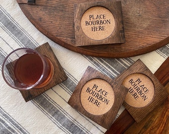 May include: Four wooden coasters with cork inserts. Each coaster has the text "Place Bourbon Here" engraved on the cork.