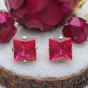 Puede incluir: Un par de pendientes de plata con piedras preciosas rosas cuadradas.