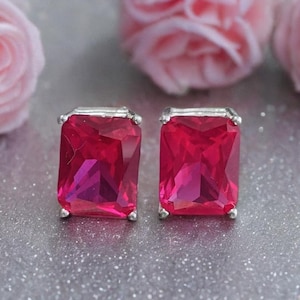 Puede incluir: Un par de pendientes de plata con piedras preciosas cuadradas de color rosa brillante.