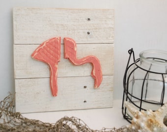 Arte de madera con un pequeño flamenco rosa sobre madera desgastada recuperada. Concientización sobre el cáncer de mama.
