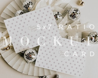 May include: Two white 5x7 ratio greeting cards with a light gray polka dot pattern. The cards are laying on a silver tray with silver disco balls and white paper flowers. The text "Citrus Press Co." is written on the cards. The text "5x7 Ratio Mockup Card" is written on the image. The text "CPCO IMAGES" is written at the bottom of the image.