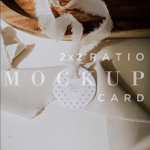 May include: A white card with a polka dot pattern and the text "Citrus Press Co." in a handwritten font. The card is tied with a white ribbon and is lying on a white surface. 2x2 ratio mockup card.
