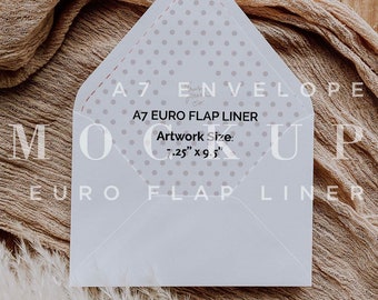 May include: A white A7 envelope liner with a gray polka dot pattern. The liner is on a brown wooden surface with a beige fabric and a white pampas grass plume. The text on the liner reads "A7 EURO FLAP LINER" and "Artwork Size: 7.25" x 9.5" ".