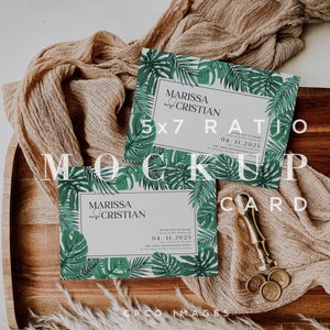 May include: Two 5x7 inch tropical-themed wedding invitations with a green and white color scheme. The invitations feature a leafy border with the text "MARISSA & CRISTIAN" and the date "04.11.2025".