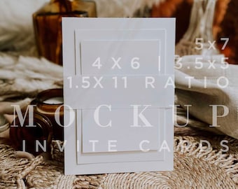 May include: A white invitation card mockup with various sizes: 5x7, 4x6, and 3.5x5 inches. The text "MOCKUP INVITE CARDS" is visible. The cards are arranged on a textured, neutral-toned surface, with decorative elements in the background.