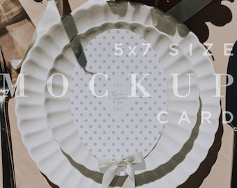 May include: A mock-up card with a polka dot design, placed on a white plate with a ruffled edge. The card is labeled "5x7 SIZE MOCK UP CARD" in white text. A white ribbon is tied at the bottom of the card. Grapes and a fork are visible.