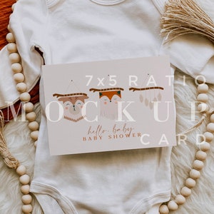 Pu&ograve; includere: Un body bianco per neonato con un biglietto di baby shower 7x5 con un design di volpe e cervo. Il biglietto dice "hello, baby baby shower card".