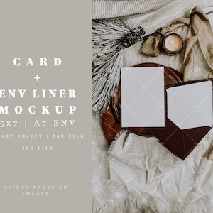 Könnte beinhalten: Ein Mockup einer weißen Karte und eines Umschlags auf einem Holztablett mit weißem Stoffhintergrund. Die Karte und der Umschlag sind leer und bereit für Ihr Design. Der Text "CARD + ENV LINER MOCKUP 5x7 | A7 ENV SMART OBJECT | PSD FILE JPG FILE CITRUS PRESS CO IMAGES" ist auf der linken Seite des Bildes gedruckt.