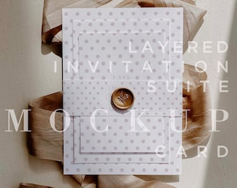 May include: Layered invitation suite mockup with a white background and a brown ribbon. The invitation suite is printed with a light purple polka dot pattern. The text on the invitation reads "Layered Invitation Suite".