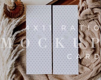 May include: A mockup card with a 4x11 ratio, featuring a light gray polka dot pattern. The card is displayed on a beige fabric with decorative elements including dried plants and a brown glass vase. Text on the card reads "MOCK UP CARD".