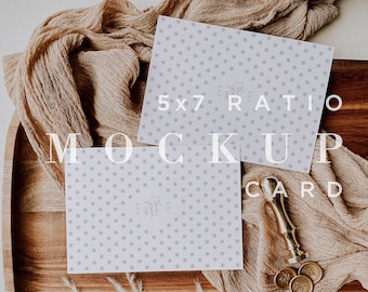May include: Two white cards with a gray polka dot pattern on a wooden tray. The cards are 5x7 ratio and have the text "5x7 Card" written on them. The tray is surrounded by a beige fabric and a white fluffy rug. There are three gold wax seals on the tray.
