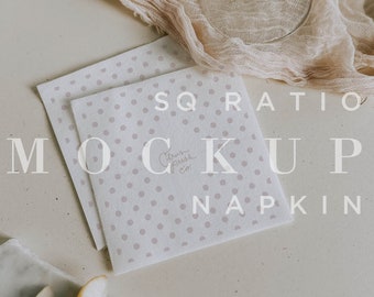 May include: Two white square napkins with a light pink polka dot pattern. The napkins are stacked on top of each other. The text "SQUARE RATIO MOCKUP NAPKIN Citrus Press Co." is printed on the napkins.