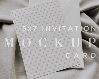 May include: A white 5x7 inch invitation card mockup with a gray polka dot pattern. The card is on a gray fabric background.