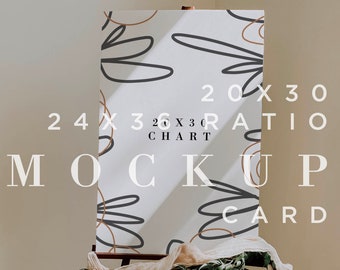May include: A white card mockup with a brown and black abstract design on an easel with greenery and a beige fabric draped over it. The card is 20x30 inches and the text on the card reads "20x30 Ratio Chart Mockup Card".