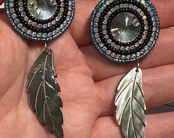 Beaded round earrings with a dangling black mother of pearl shell feather