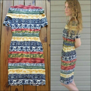 May include: A vintage style dress with a colorful striped pattern featuring blue, red, yellow, and green. The dress has a fitted bodice and a slightly flared skirt.