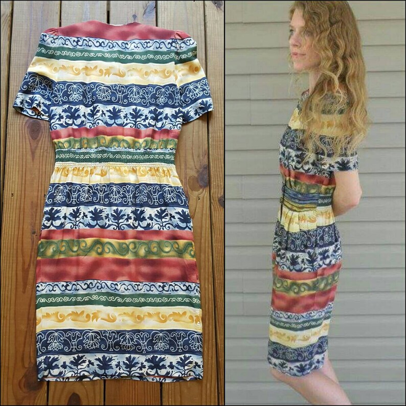 May include: A vintage style dress with a colorful striped pattern featuring blue, red, yellow, and green. The dress has a fitted bodice and a slightly flared skirt.