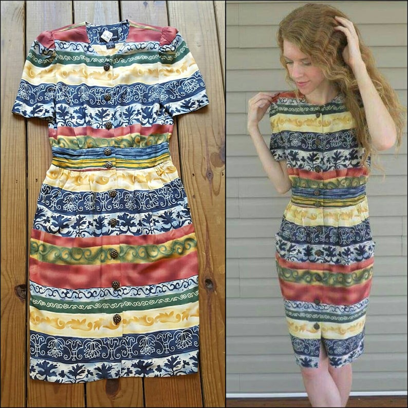 May include: A colorful, striped dress with a button-up front and short sleeves. The dress has a floral pattern and is made of a silky fabric.