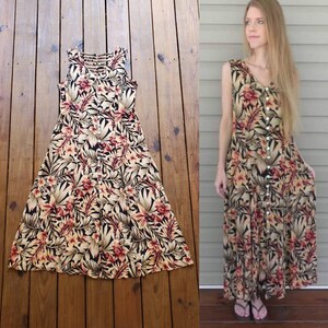May include: A sleeveless maxi dress with a floral print in shades of brown, beige, and red. The dress has a button-up front and a V-neckline.
