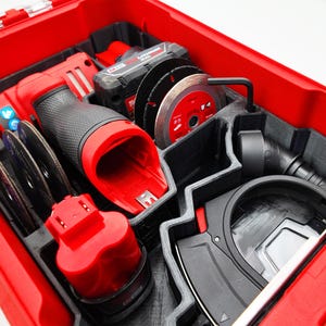 May include: A red toolbox with black and gray compartments, filled with power tools and accessories. Includes a red and black grinder, circular saw blades, and a battery pack. The tools are neatly organized within the case.