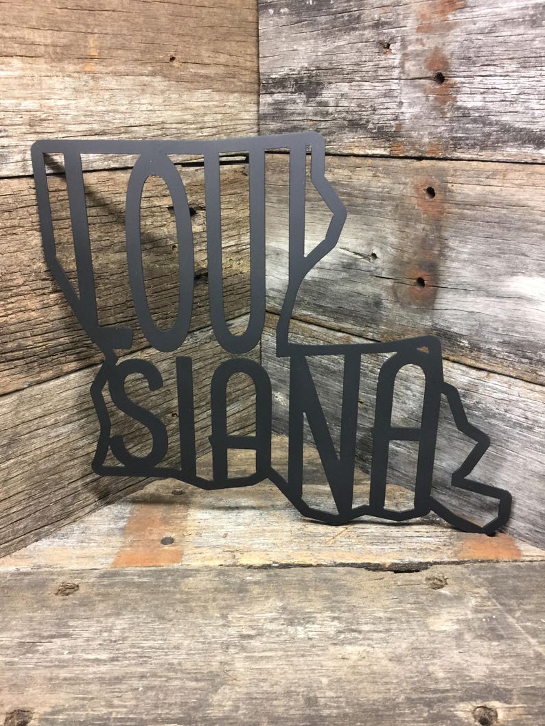 May include: Black metal cutout of the state of Louisiana with the word "Louisiana" written inside the outline of the state.