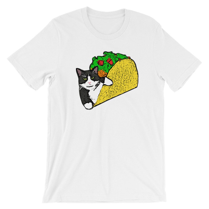May include: A white t-shirt with a black and white cat inside a yellow taco. The cat has a serious expression and is looking directly at the viewer.