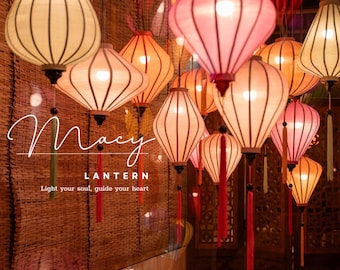 May include: A collection of hanging lanterns in various colors, including cream, pink, and orange. The lanterns have a traditional design with vertical lines and are illuminated from within. The image includes the text "Macy Lantern" and "Light your soul, guide your heart."