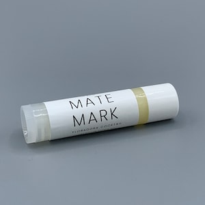 May include: White lip balm tube with the text "MATE MARK FLORADORA COCKTAIL" printed on the label.
