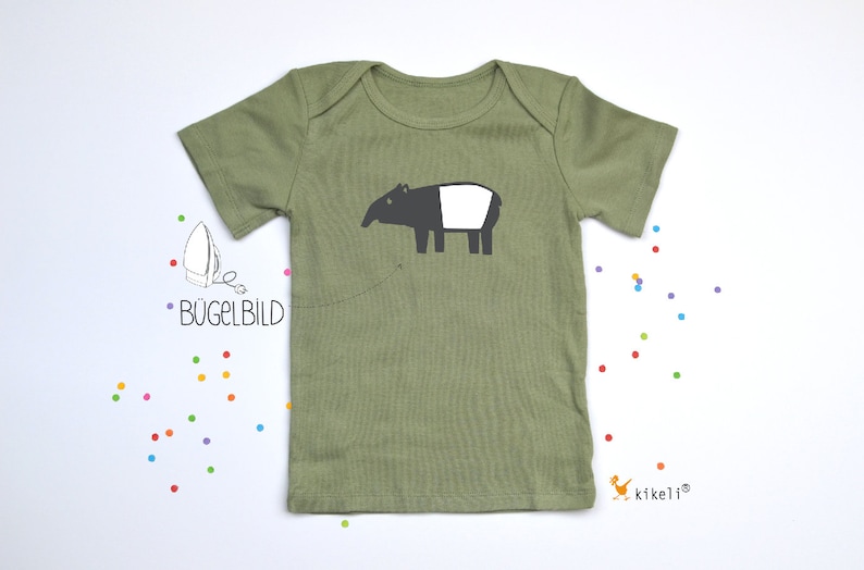 May include: A green short-sleeved t-shirt with an iron-on design of a black and white tapir. The text "B&uuml;gelbild" is visible on the shirt.