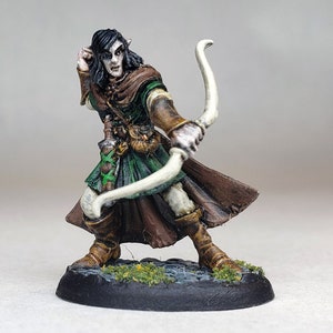 May include: A painted miniature figurine of an elf archer, wearing a green tunic, brown trousers, and a brown cloak. The elf is holding a white bow and arrow, and has a serious expression on their face.