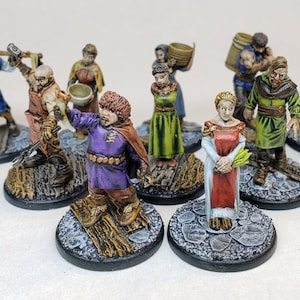 Puede incluir: Un conjunto de diez figuras en miniatura pintadas a mano, cada una de pie sobre una base redonda. Las figuras están vestidas con diversas prendas medievales, incluyendo una túnica morada, un vestido rojo y una túnica verde. Las figuras están todas pintadas en colores vibrantes y tienen detalles elaborados.