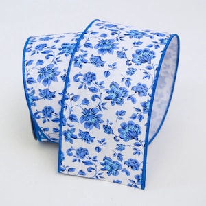 May include: A rolled-up white ribbon with a blue floral pattern. The ribbon features a repeating design of blue flowers and leaves. The edges are trimmed with a solid blue border. This decorative ribbon is suitable for crafts and gift wrapping.