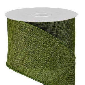 May include: A roll of olive green ribbon with a textured, woven fabric appearance. The ribbon is wrapped around a white plastic spool, featuring a consistent, dense weave pattern across its entire surface and finished edges along both sides.