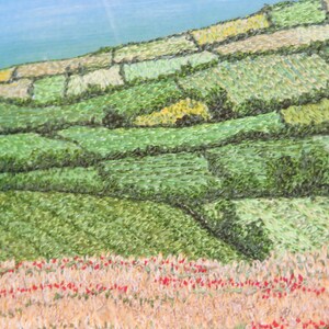 May include: An oil painting depicting a rural landscape. The image shows a hillside with terraced fields in various shades of green and brown. Red flowers are in the foreground, and a blue sky is visible in the background.