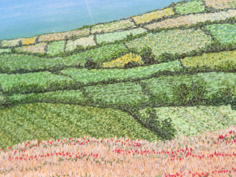 May include: An oil painting depicting a rural landscape. The image shows a hillside with terraced fields in various shades of green and brown. Red flowers are in the foreground, and a blue sky is visible in the background.