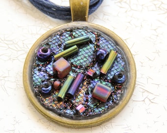 Textile and metal pendant necklace with embroidery and beads