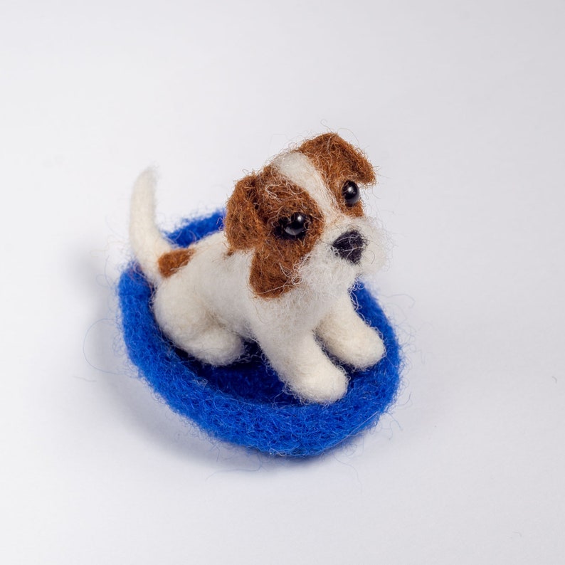 Felted Jack Russell Terrier miniature on a blue base, needle-felted wool dog figurine.