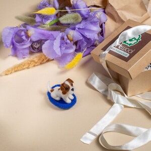 Gift presentation: felted Jack Russell miniature with lilac flowers, ribbon and a small card.