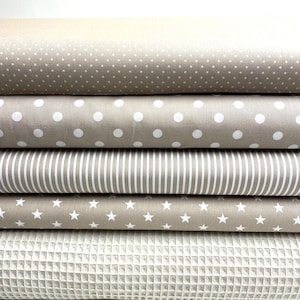 Könnte beinhalten: Fünf verschiedene Stoffmuster in Beige und Weiß. Die Muster zeigen verschiedene Designs, darunter Punkte, Streifen, Sterne und eine Waffelstruktur.
