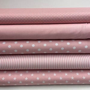 Könnte beinhalten: Fünf rosa Stoffmuster mit verschiedenen weißen Mustern. Das oberste Muster hat kleine weiße Punkte, das zweite ist einfarbig rosa, das dritte hat große weiße Punkte, das vierte hat weiße Streifen und das unterste Muster hat weiße Sterne.