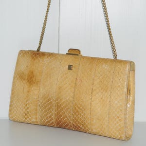 Può includere: Una pochette in pelle di serpente beige chiaro con una tracolla a catena dorata e una chiusura dorata.
