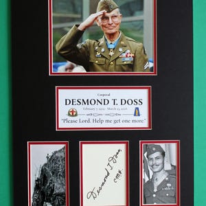 May include: A framed display featuring a portrait of Desmond T. Doss in uniform saluting, with a red, white, and blue medal. Below, a nameplate reads "Corporal Desmond T. Doss" with dates and a quote. Additional photos and a signature are included.