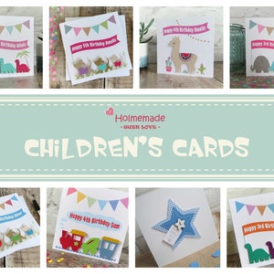 May include: A collection of square greeting cards featuring colorful die-cut designs including dinosaurs, dogs, llamas, elephants, trains, and stars. Each card displays a banner with text such as Happy Birthday and a name, plus bunting.